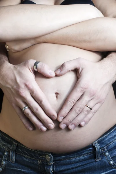 Happy pregnant on black background with crossed arms and hands o — Stock Photo, Image