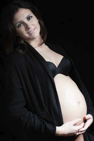 Gelukkig zwanger op een zwarte achtergrond — Stockfoto