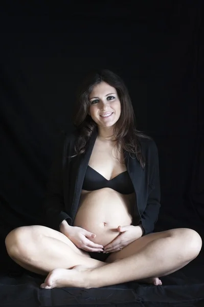 Gelukkig zwanger op een zwarte achtergrond — Stockfoto