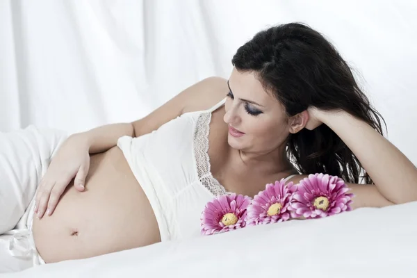 Młoda kobieta w ciąży z kwiatami — Zdjęcie stockowe