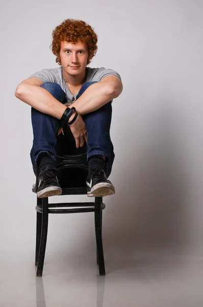 Verrückter Ingwer junger Mann auf Stuhl — Stockfoto