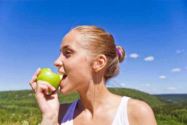 Flicka äter ett äpple. — Stockfoto
