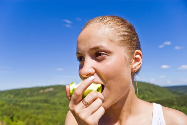 Flicka äter ett äpple. — Stockfoto