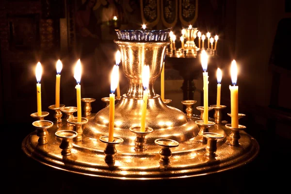 Kaarsen en een lamp branden in de kerk. — Stockfoto
