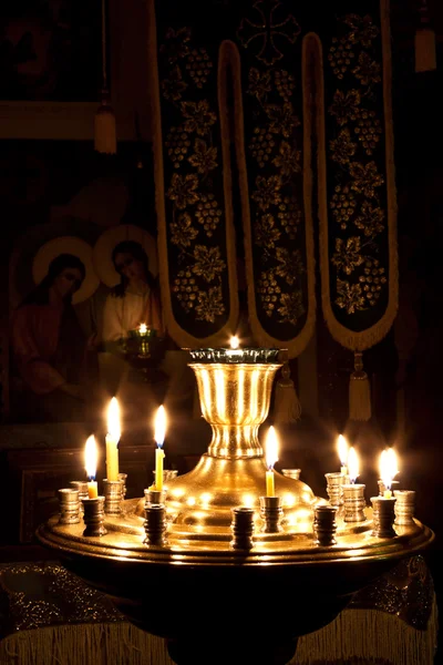 Velas e uma lâmpada acesa na igreja . — Fotografia de Stock