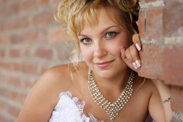Porträt einer schönen jungen Braut gegen Backsteinmauer — Stockfoto