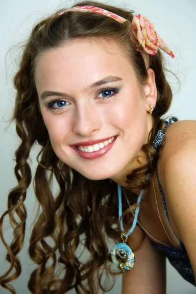 Retrato de una joven bonita y sonriente con largos bucles en el pelo — Foto de Stock