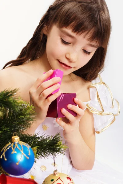 Little smiling girl opening christmas present — Stock Photo, Image