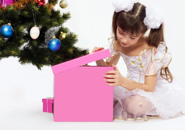 打开圣诞礼物的小微笑女孩 — 图库照片