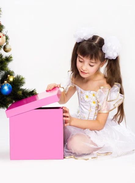 Kleines Mädchen öffnet Weihnachtsgeschenk — Stockfoto