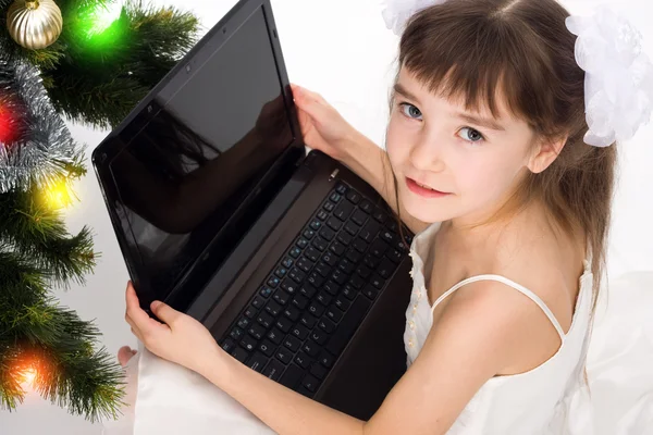 小姑娘微笑着与便携式计算机 — 图库照片