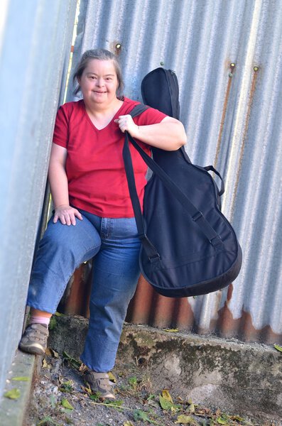 Женщина с синдромом Дауна с гитарой
