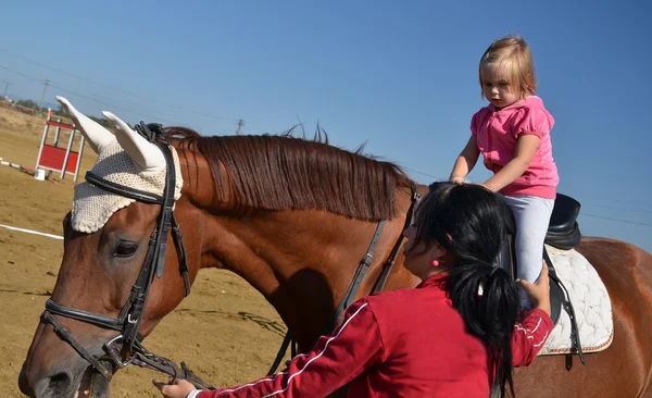 Bardzo mała dziewczynka na czarnego konia — Zdjęcie stockowe