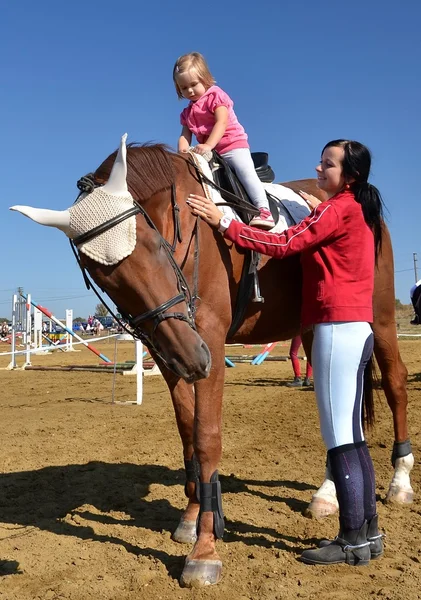 Nagyon kis lány a lány fekete ló — Stock Fotó
