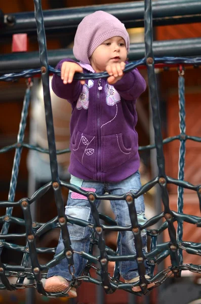 Kleines Mädchen spielt auf Kinderspielplatz — Stockfoto