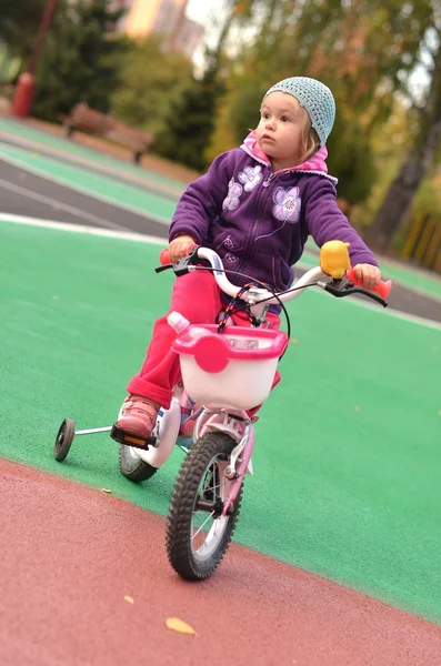 Malá holčička na její růžové kolo — Stock fotografie