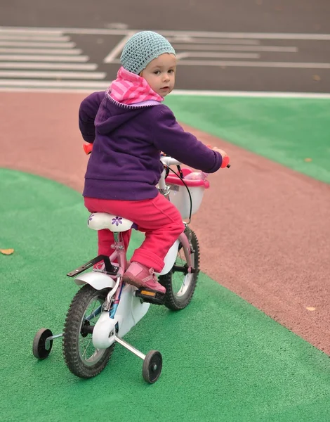 Malá holčička na její růžové kolo — Stock fotografie