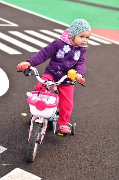 Маленькая девочка едет на розовом велосипеде — стоковое фото