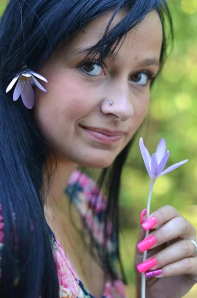 Schöne junge brünette Frau mit Blume im Haar — Stockfoto