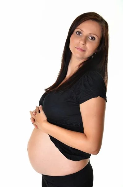 Femme enceinte caressant son ventre sur fond blanc — Photo