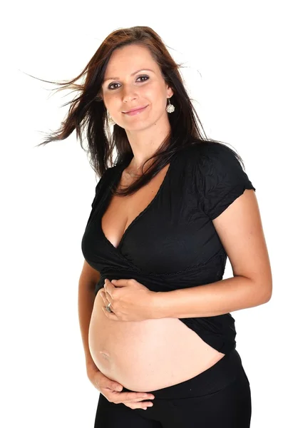임신 한 여자가 하얀 배경으로 배를 긁고 있는 모습 — 스톡 사진