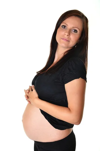 Pregnant woman caressing her belly over white background Stock Image