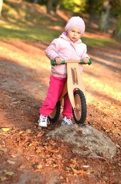 Küçük kız üzerinde ahşap bisiklet sürme — Stok fotoğraf