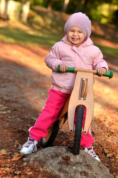 小女孩骑着她的木头自行车 — 图库照片
