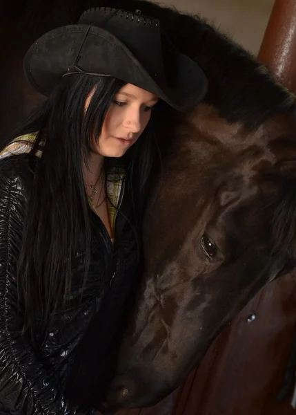 Счастливая девушка обнимает коричневую лошадь — стоковое фото