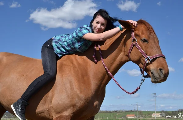 Šťastná dívka všeobjímající hnědý kůň — Stock fotografie