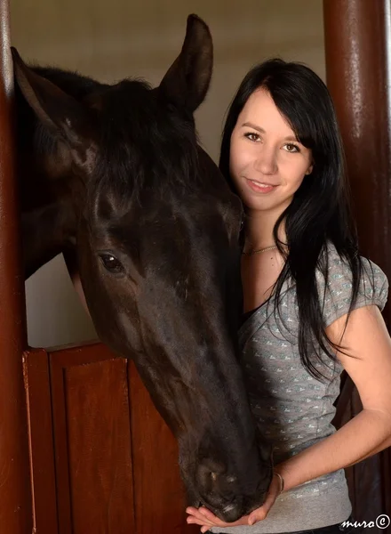 Glückliches Mädchen umarmt braunes Pferd — Stockfoto