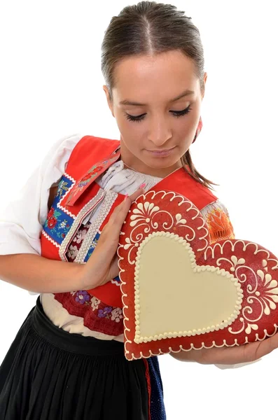 Όμορφη κοπέλα δείχνει μια καρδιά άρτος αρωματισμένος με τζίντζερ — Φωτογραφία Αρχείου