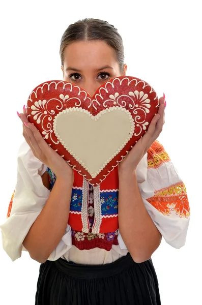 Beautiful girl shows a gingerbread heart — Stock Photo, Image