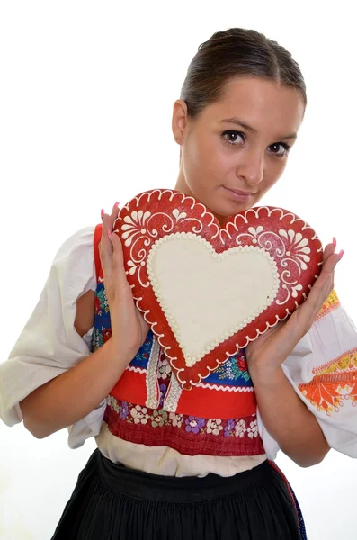 Beautiful girl shows a gingerbread heart — Stock Photo, Image