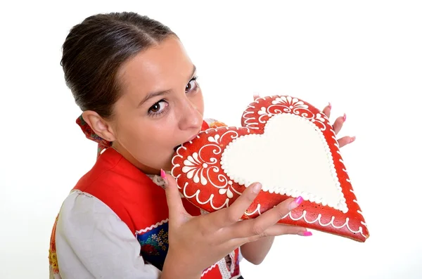 Όμορφη κοπέλα δείχνει μια καρδιά άρτος αρωματισμένος με τζίντζερ — Φωτογραφία Αρχείου