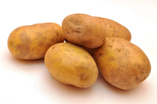 Μερικές κίτρινο πατάτες που απομονώνονται σε λευκό φόντο — Φωτογραφία Αρχείου