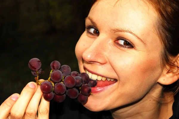 Junge schöne Frau hält eine Weintraube — Stockfoto