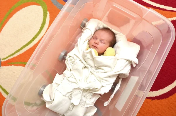 Újszülött baba nyitott műanyag dobozban — Stock Fotó