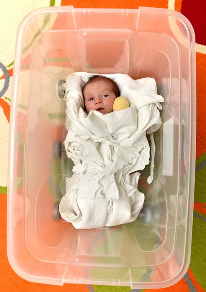 Bebê recém-nascido em caixa de plástico aberta — Fotografia de Stock
