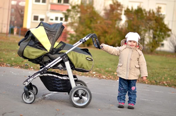 Baby pushing stroller Royalty Free Stock Images