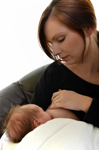 Мати годує новонароджену дитину грудьми - в приміщенні — стокове фото