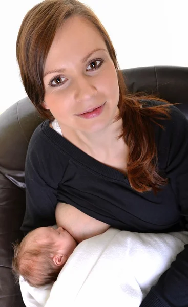 Mutter füttert ihr Neugeborenes mit der Brust - drinnen — Stockfoto