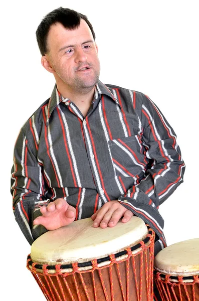 Szczęśliwy człowiek z zespołem Downa, gra na bębnie. — Zdjęcie stockowe