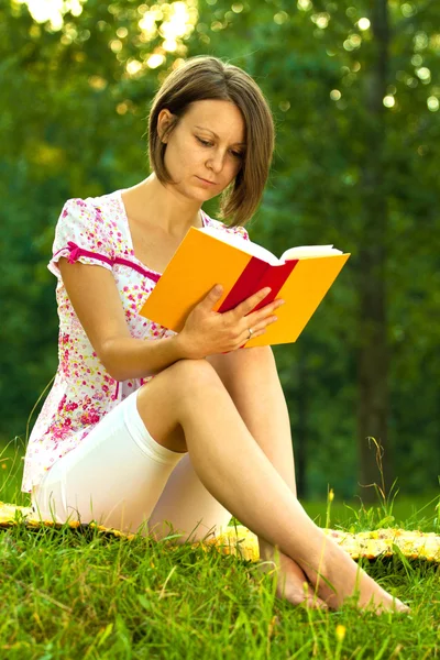 Beautiful woman immersed in a romantic book — Stock Photo, Image