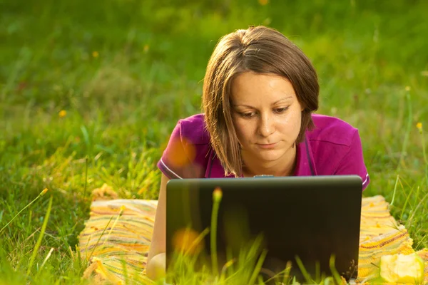 stock image Beautiful woman with a laptop in the park