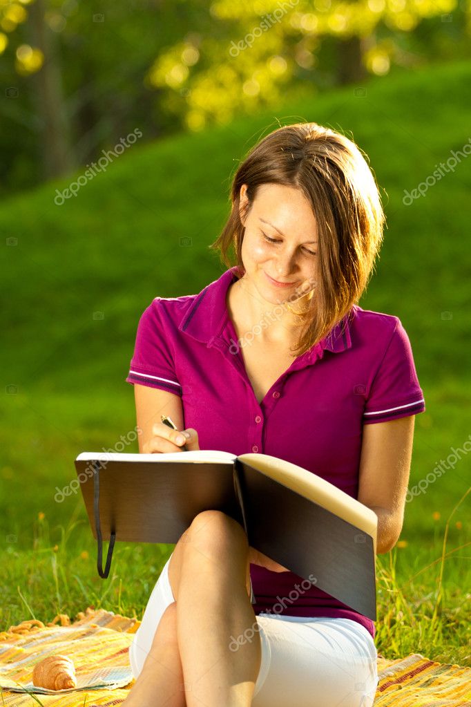 Femme écrivant dans un journal intime image libre de droit par