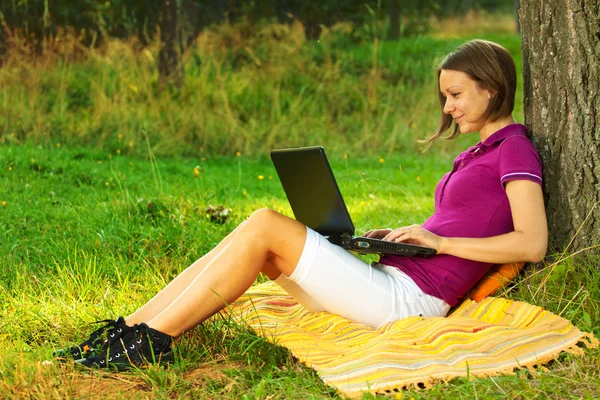 Mulher animada bonita com um laptop no parque Imagens De Bancos De Imagens Sem Royalties