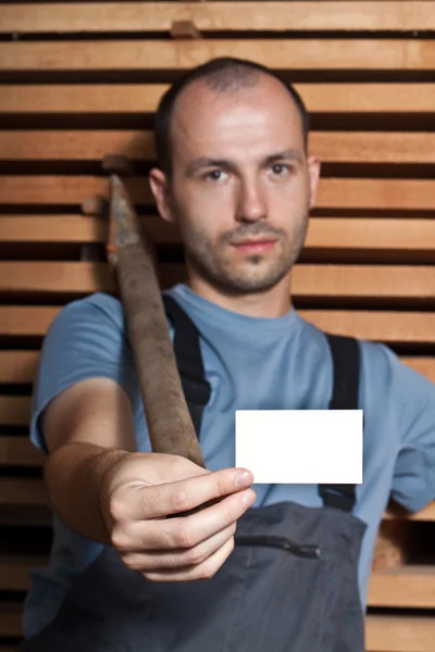 Craftsman with a hammer holding a business card — Stock Photo, Image