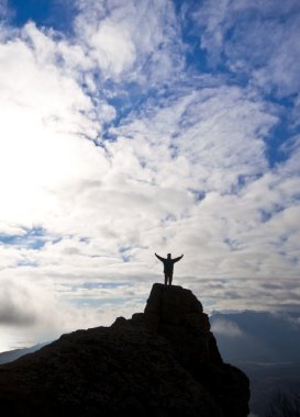 Woman on top of the mountain reaches for the sun clipart
