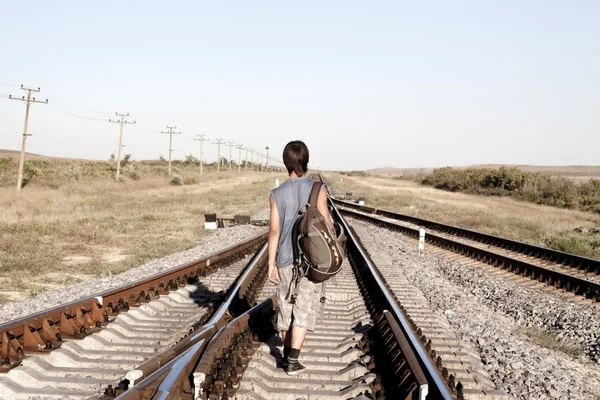 Teen boy walking on rail road — Stock Photo, Image